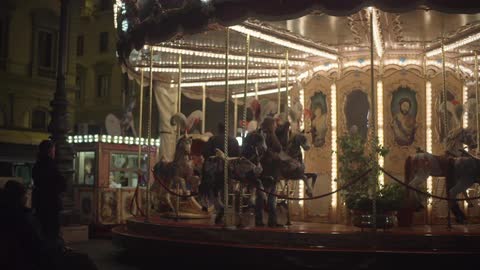A merry go round in an old city square lit up at night