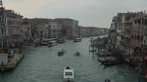 Boats traveling down a canal near a city
