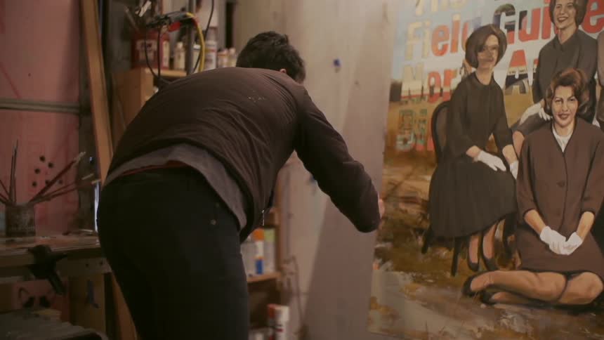 Man finishing up a painting in his workshop