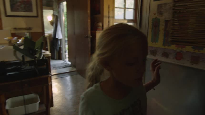 Girl gets up from a table and runs into a room