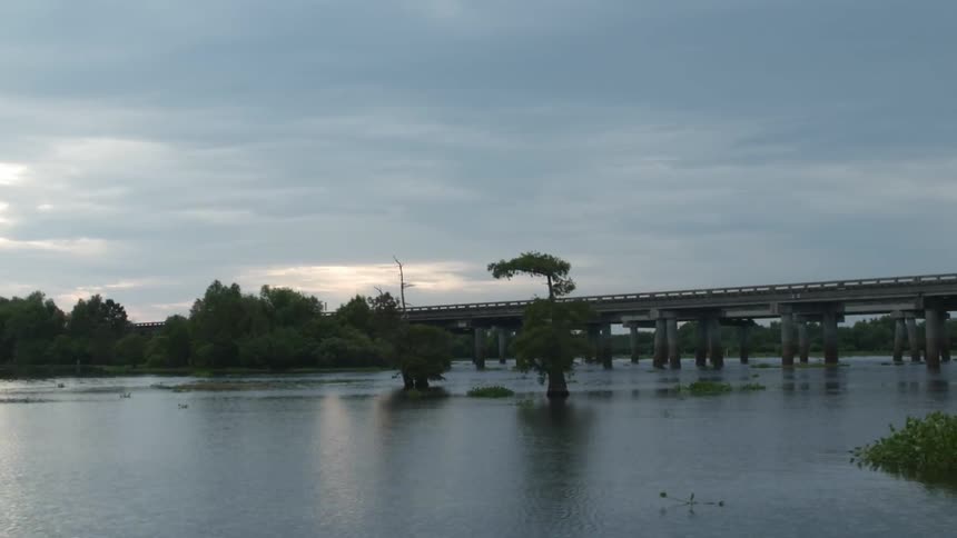 View of a bridge over a small body of water on a cloudy day