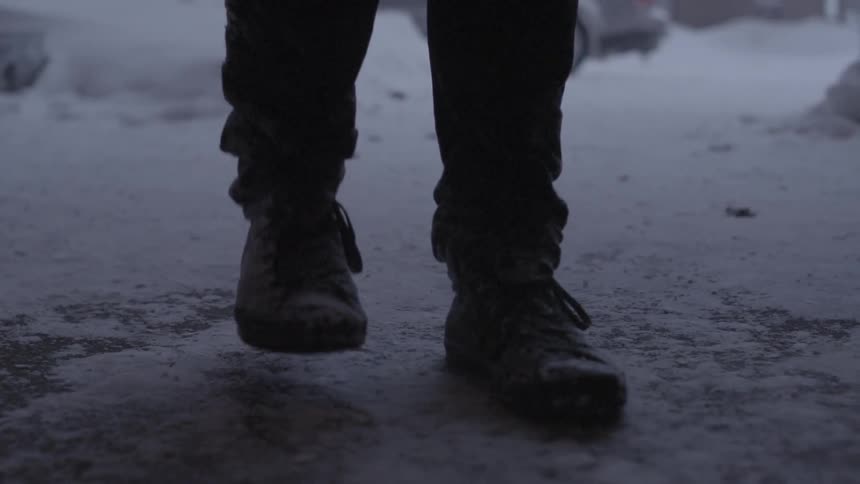 Man stomping snow off of his boots