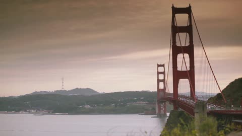 A view of the san francisco bridge and shoreline as traffic passes on the bridge