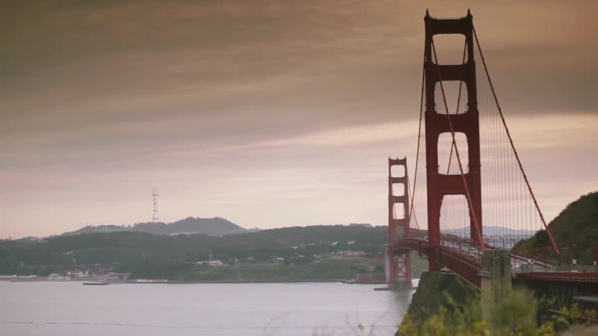 A view of the san francisco bridge and shoreline as traffic passes on the bridge