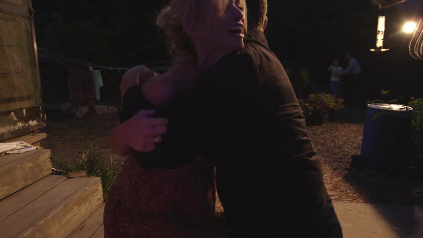 A man walks a woman to seat her on steps