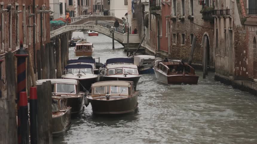 Boats docked and floating down a narrow canal