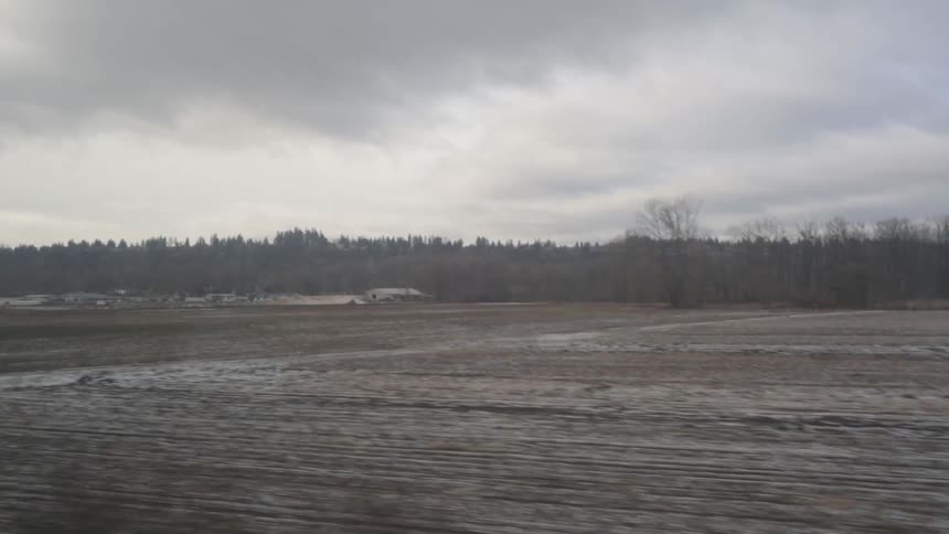 A snowy plowed field on a cloudy day