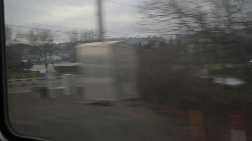 A view of buildings, parking lots and mountains out of a window