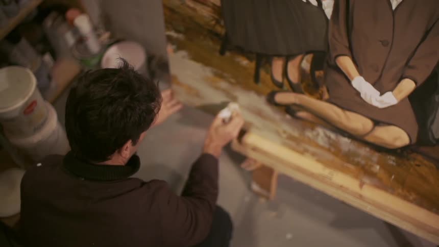 Man finishing a painting in his workplace
