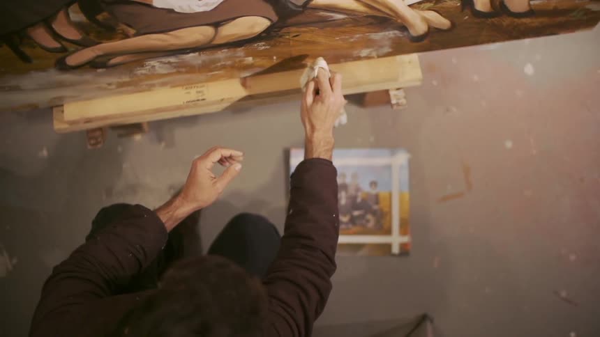Person using a cloth to modify their oil painting
