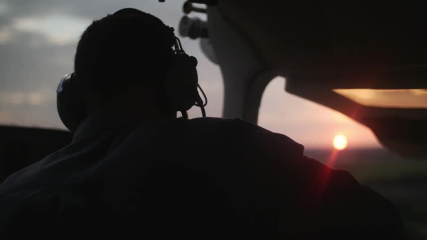 Pilot in a dark cockpit driving an airplane