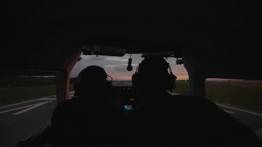 A plan goes down the runway preparing to take off at sunset