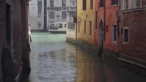 Ferry traveling through a canal in between buildings