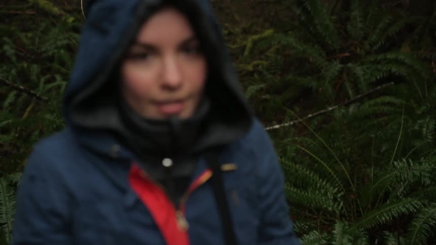 Woman runs in the woods stops and smiles