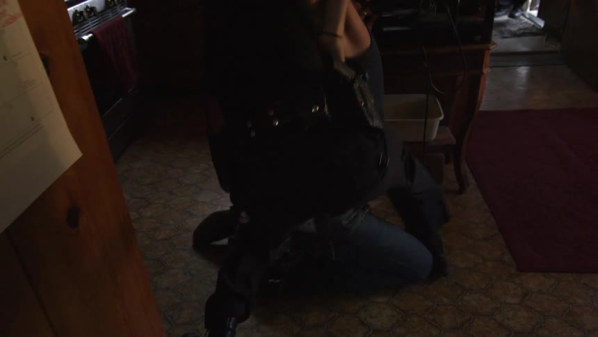 A cop tackles a man in the kitchen