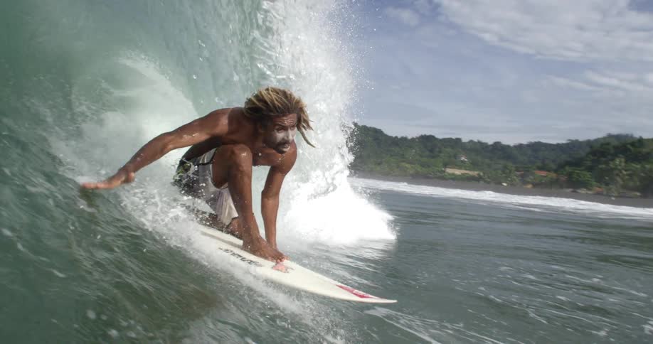 A man surfing and a wave pushing him under water