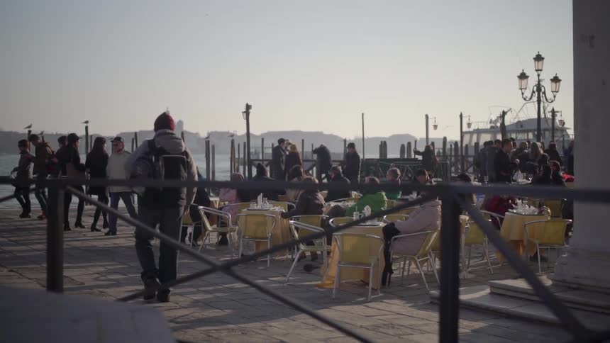 People sitting and walking on a pier on a cloudy day