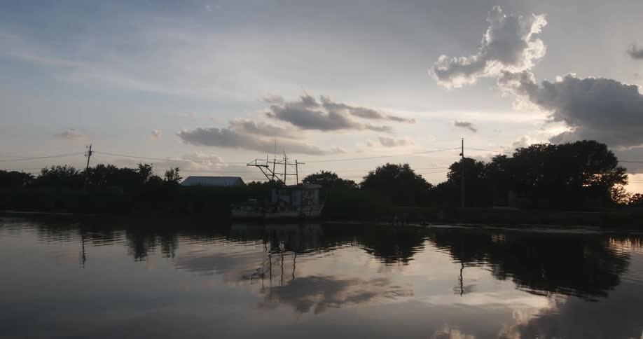 A boat sitting in water at sunrise