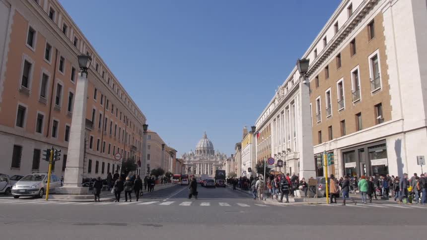 Street with buildings on each side and people walking on a sunny day