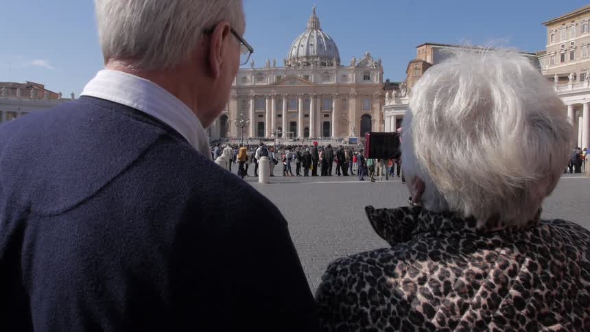 Busy square as a couple take a photo of a building
