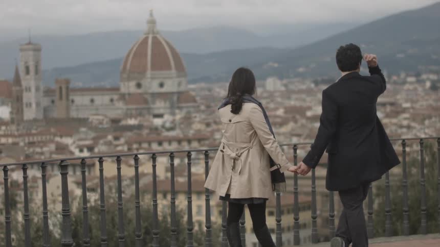 A couple holds hands while enjoying the scenery