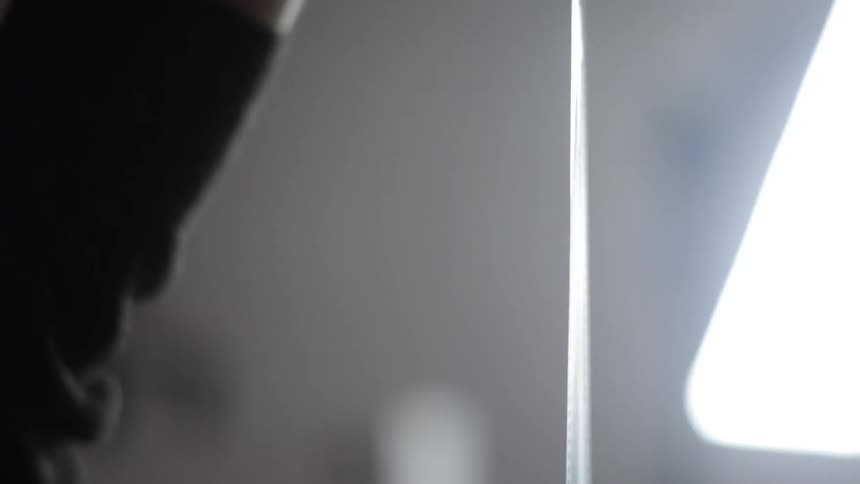 Man holds up a roll of film to a light for examination