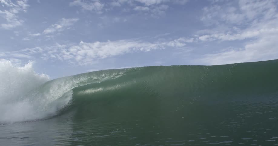 A long ocean wave cresting and crashing over
