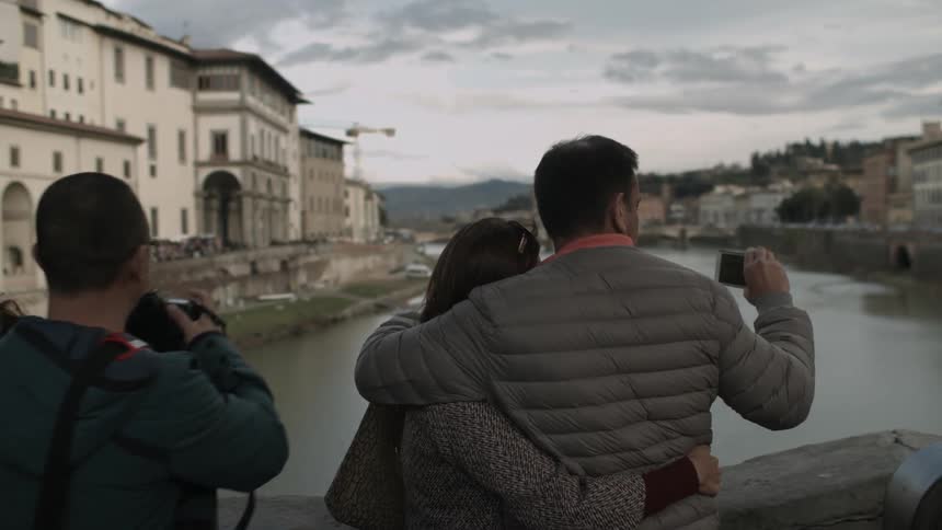 Couple embrace and take photos on a cloudy day