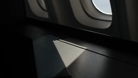 Sunlight comes through a small airplane window