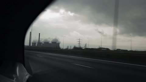 A car moving fast down a road on a cloudy day