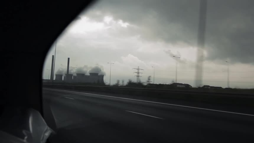 A car moving fast down a road on a cloudy day