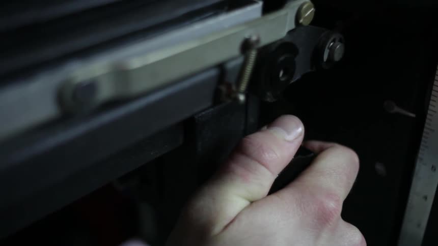 A man using a knob to adjust a piece of equipment