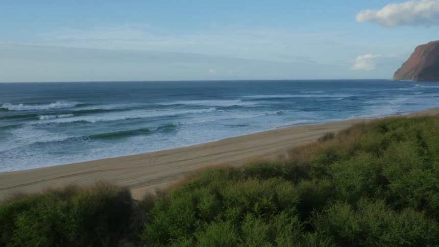 Blue ocean waters crashing onto a beautiful sandy beach