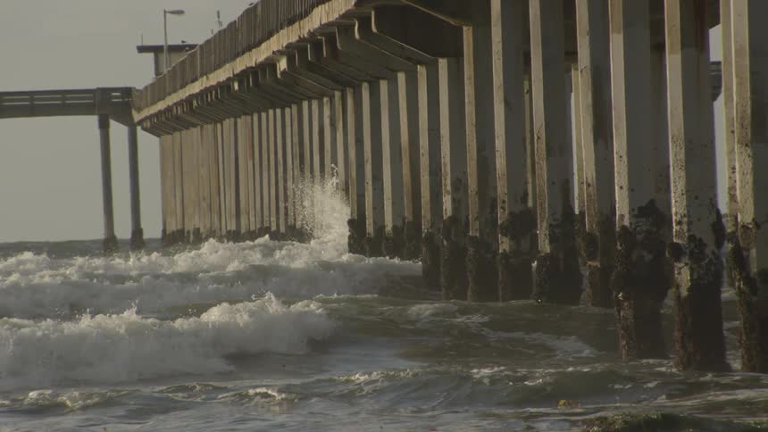 Waves crashing against pier supports
