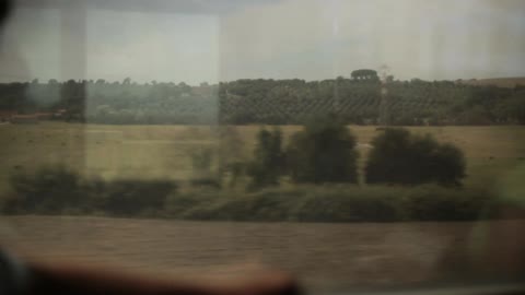 A passenger train rides through a rural area