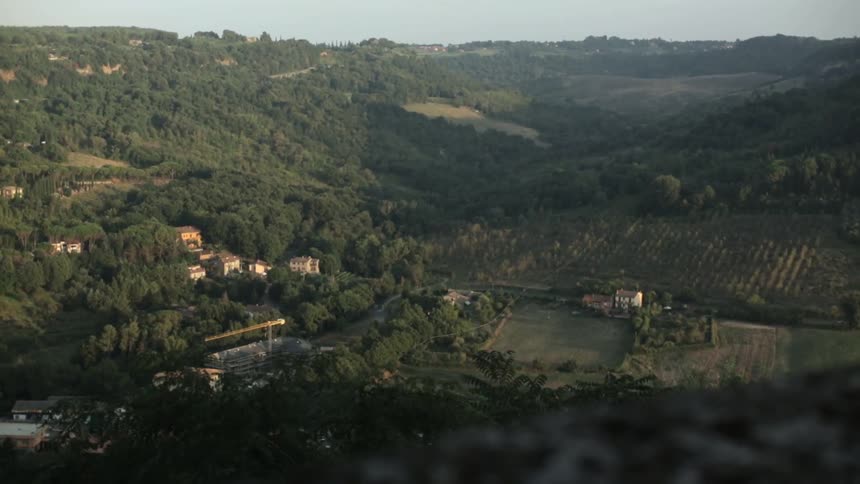 Houses are built along the side of a hill in the countryside