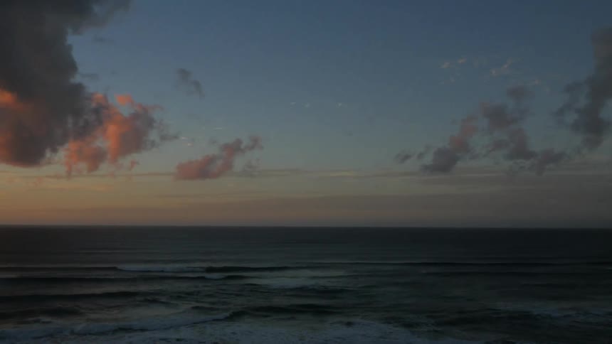 Pan of a beach at sunset