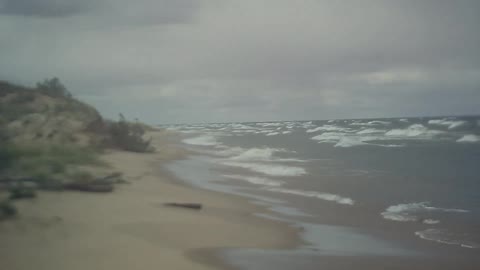 Cloudy beach with waves crashing on the shore