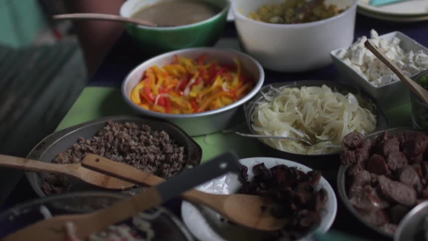 People scooping food out of bowls