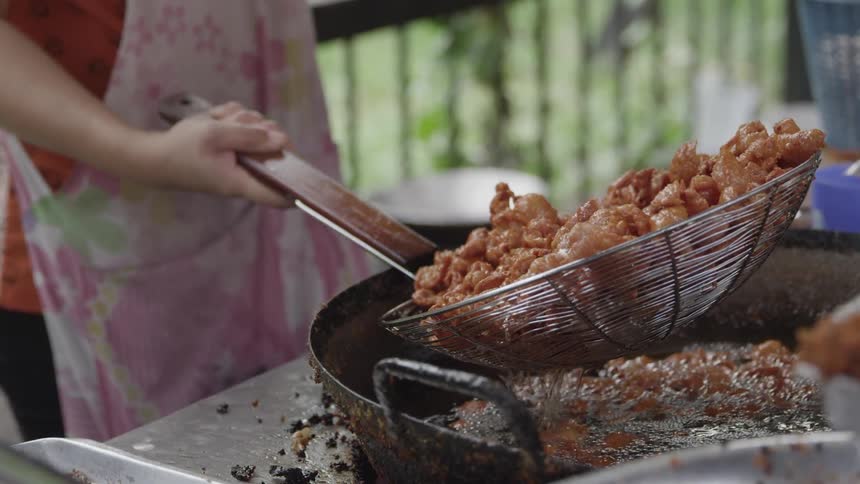 A woman is frying shrimp