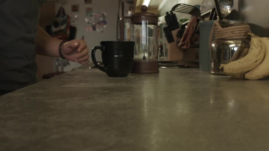 Man puts a mug and empty pitcher on a counter