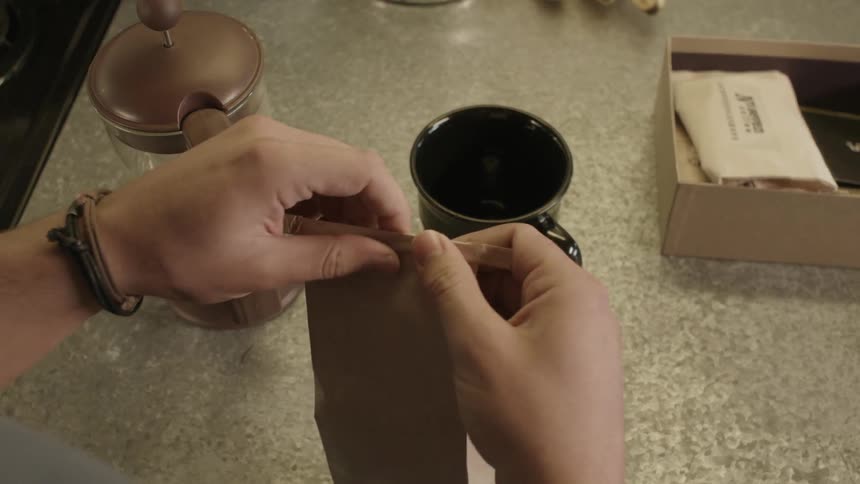 A man unwraps and opens a bag