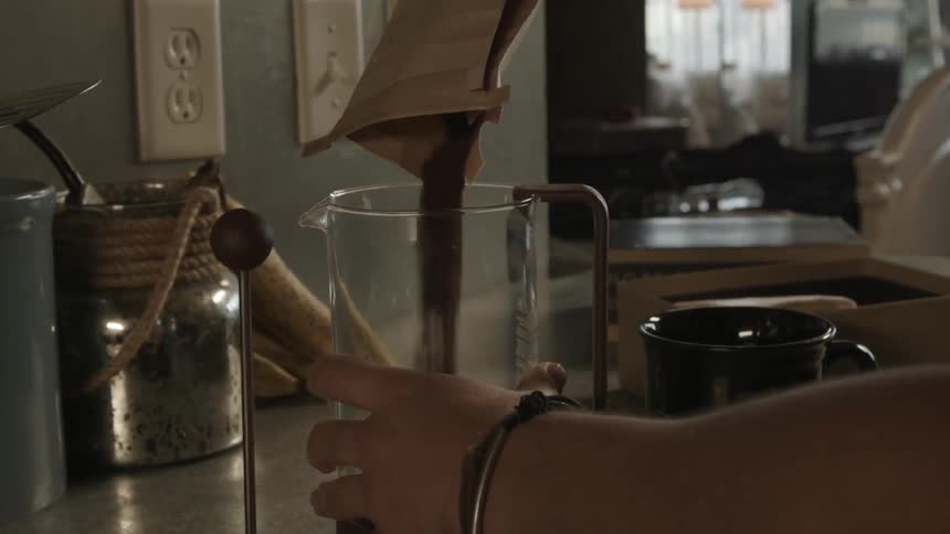 Person filling a pitcher with coffee