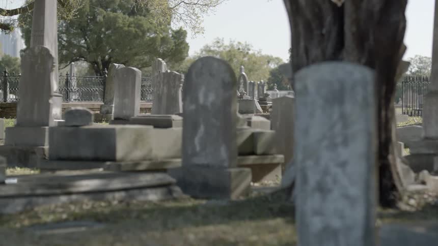 Grass and tombstones on a cloudy day in a cemetery