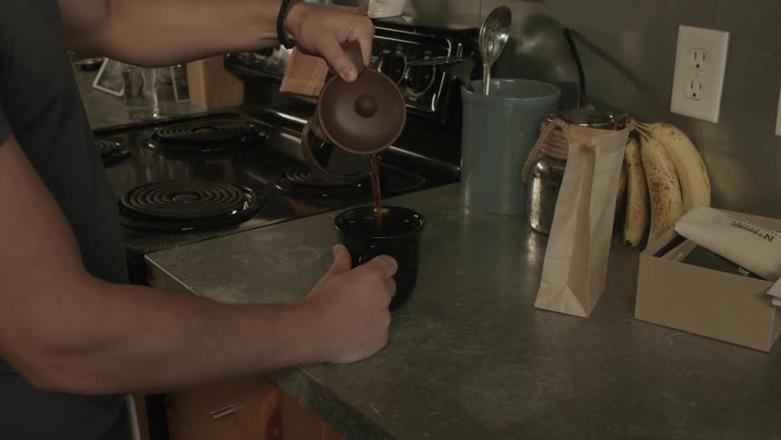 Man pouring coffee into a mug