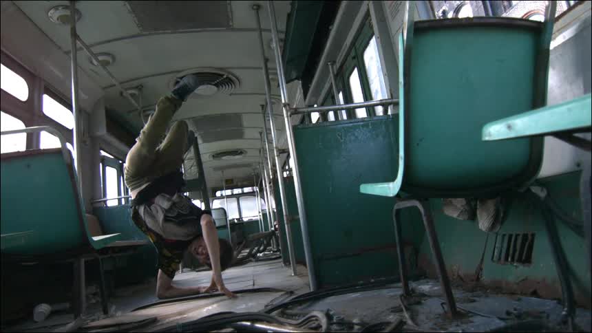Teen male breakdancing in an abandoned bus