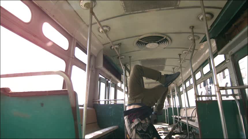 A man break dancing inside a bus