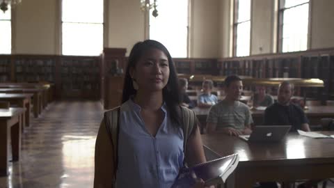 A woman walks through a library