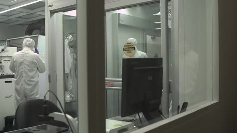 Doctors in decontamination suits work in a lab
