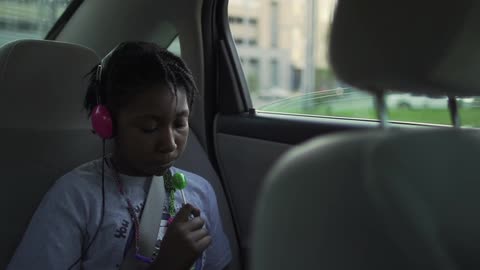 The child sits with the lollipop in the car